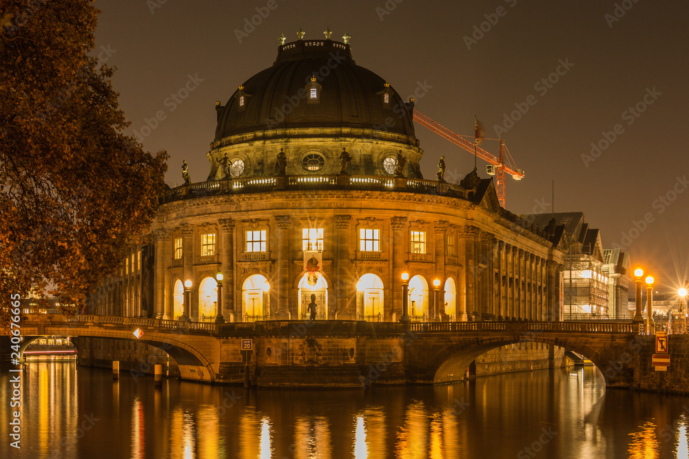 Museum Island at night in the center of Berlin. autumn mood on the river spree with bridges. Light reflects in the water from the river. Historic buildings in the foreground