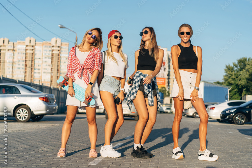 Four young girls have fun at the car park.