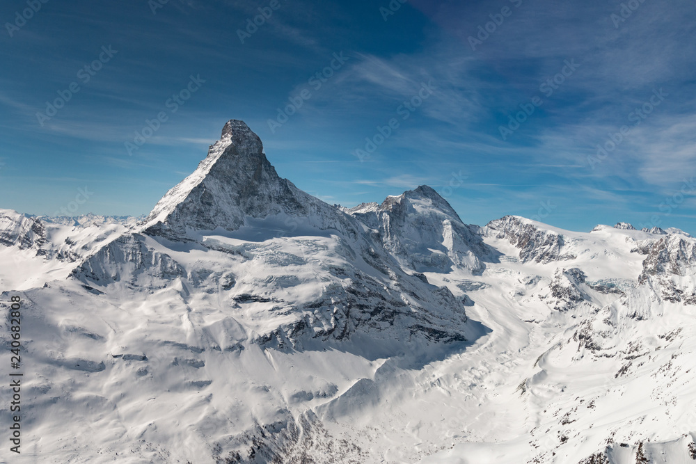 Aerial view of majestic Matterhorn mountain in front of a blue sky.