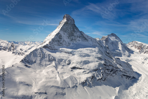 Aerial view of majestic Matterhorn mountain in front of a blue sky © A. Emson