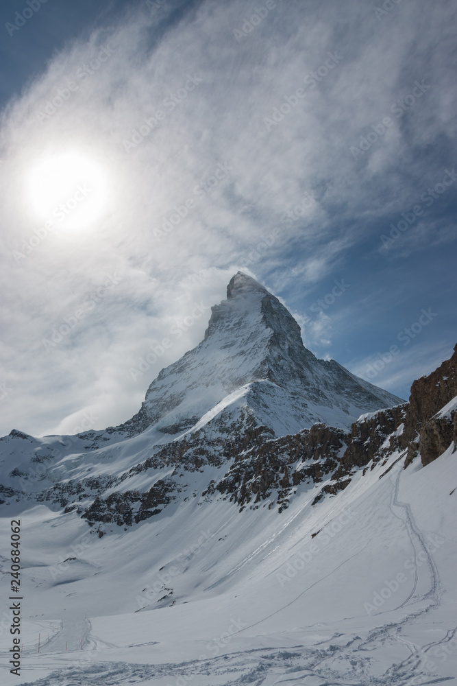 Majestic Matterhorn mountain in front of a partly cloudy sky 