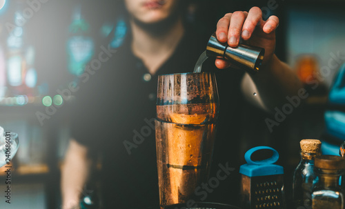 A barman pours alcohol into a shaker for a cocktail. Great plan.
