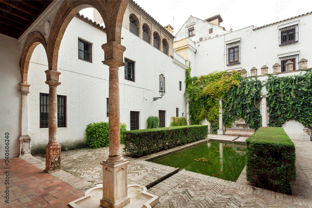 Columns in green courtyard of Alcazar, example of Mudejar architecture of the 14th century, historical royal palace