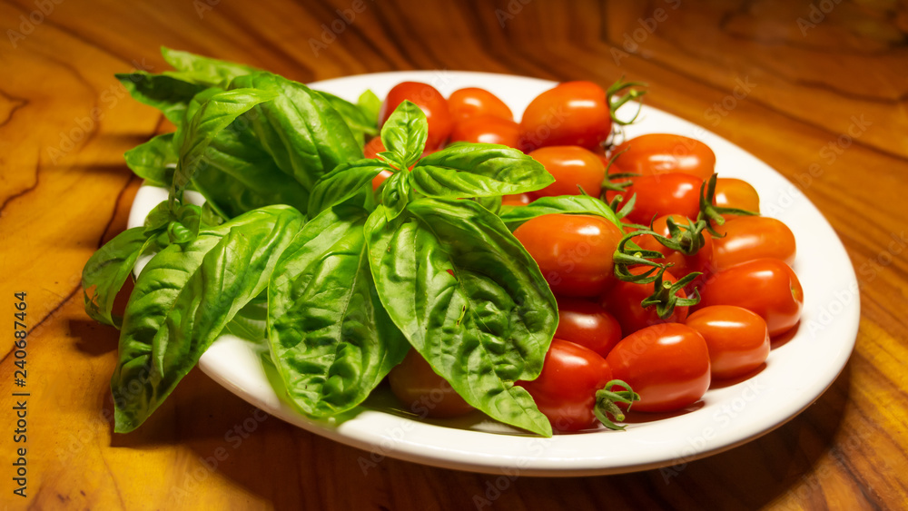 A plate of Fresh organic tomatoes and basil A plate of Fresh organic tomatoes and basil