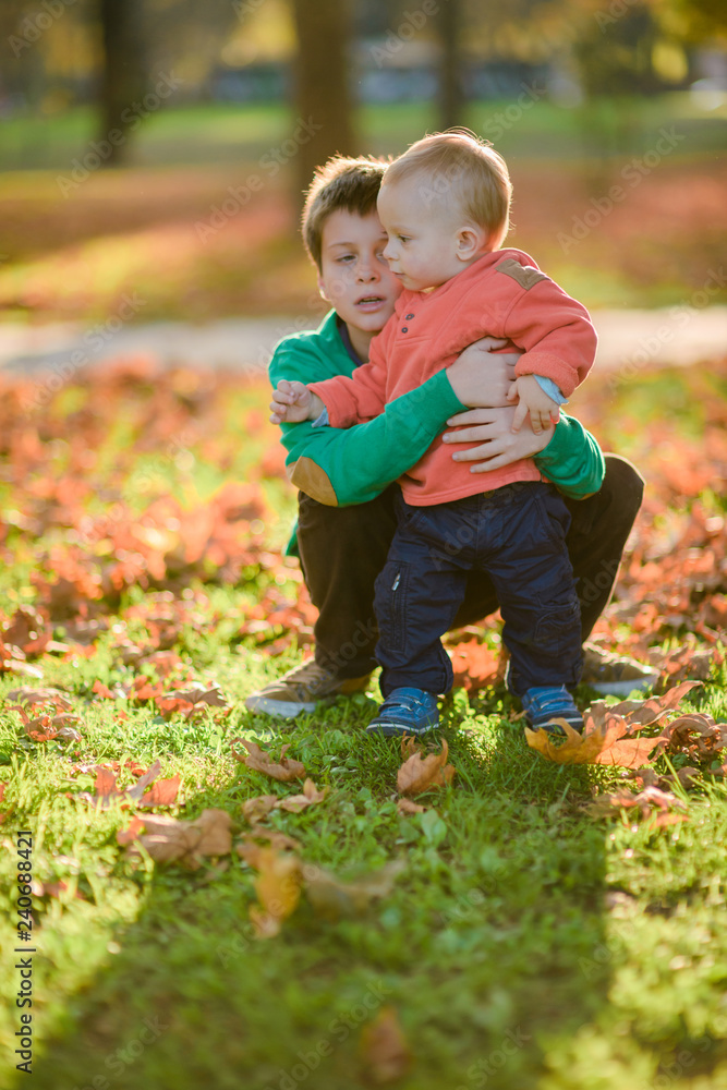 Little boy and toddler posing in the park Little boy and toddler posing in the park