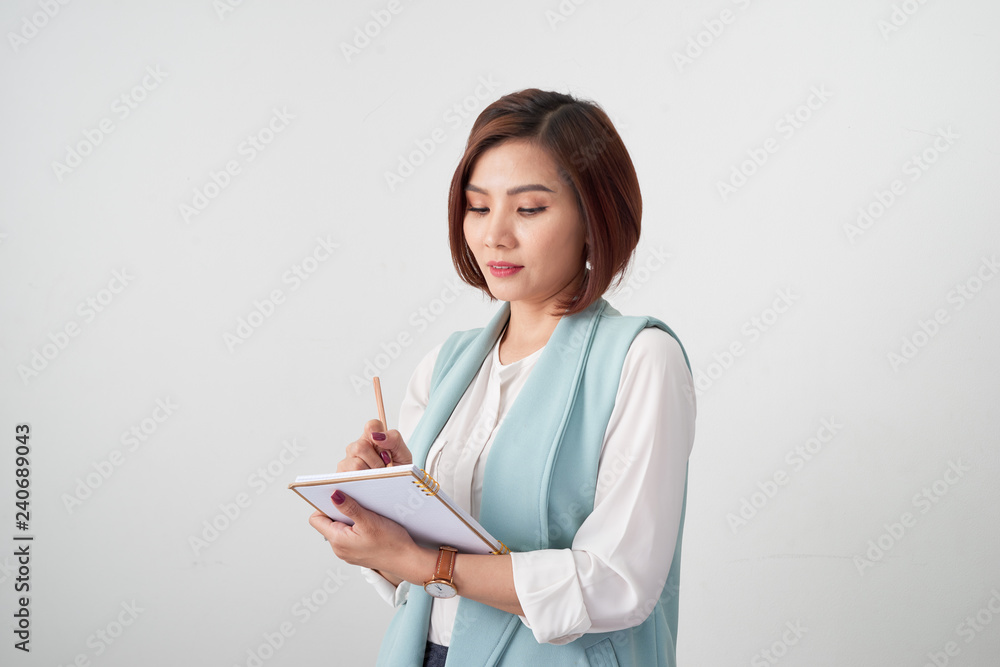 Portrait of young smiling businesswoman in the office, holding documents on light background Portrait of young smiling businesswoman in the office, holding documents on light background
