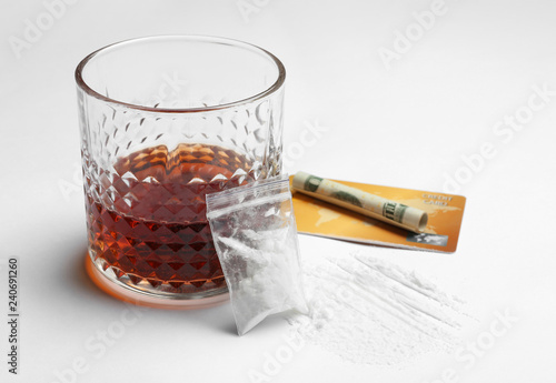 Composition with cocaine and glass of alcohol on white background photo