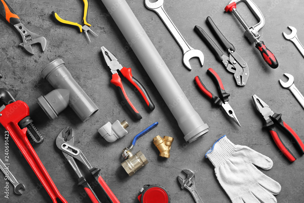 Flat lay composition with plumber's tools on grey background Flat lay composition with plumber's tools on grey background