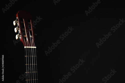 Acoustic guitar on black background, closeup. Space for text