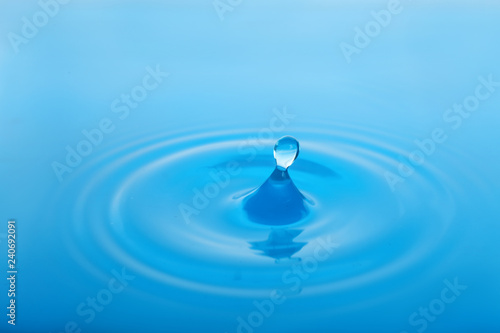 Splash of blue water with drop as background, closeup