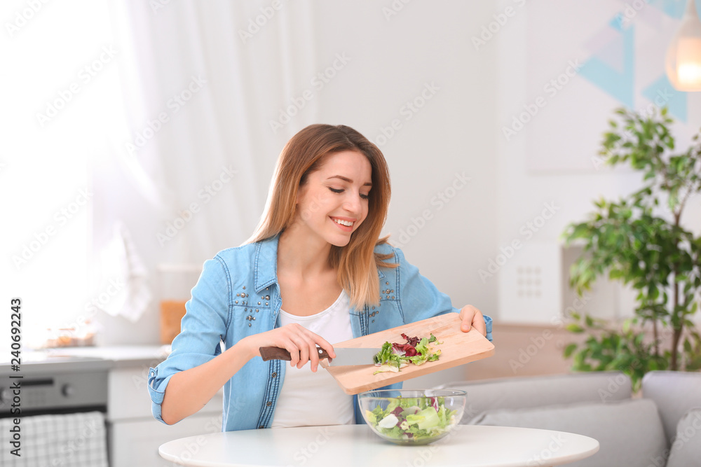 Happy young woman preparing salad in kitchen. Healthy diet Happy young woman preparing salad in kitchen. Healthy diet
