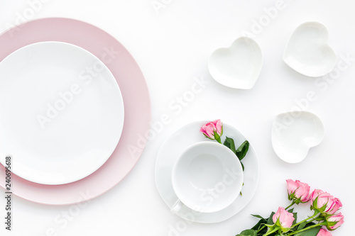 Table setting with plates and flower on white kitchen background top view copy space