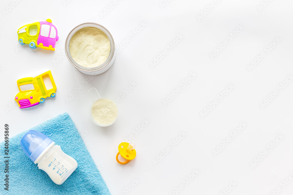 Obraz premium Handmade toys for newborn baby. Rattle. Feeding bottle with milk. White background top view mockup