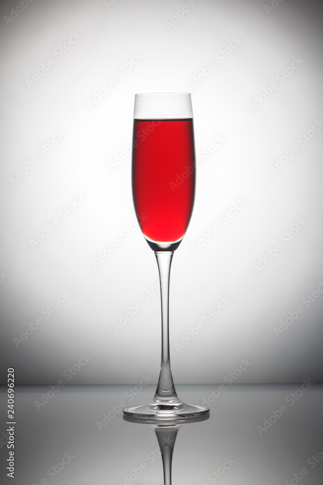 Red wine in а glass on grey background. Red wine in а glass on grey background.