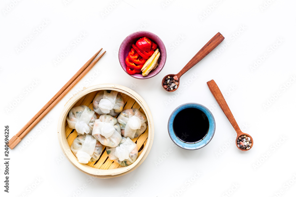 Dinner in Chinese restaurant with dim sum, sticks and tea on white background top view Dinner in Chinese restaurant with dim sum, sticks and tea on white background top view