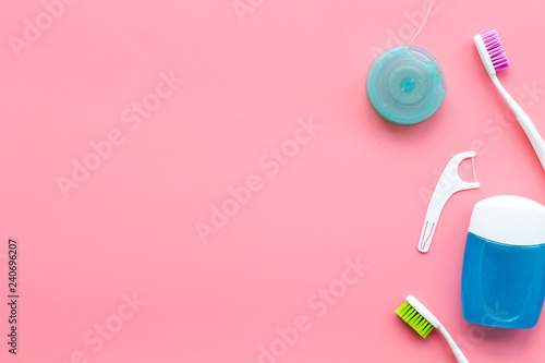 Daily oral hygiene for family. Toothbrush and dental floss on pink background top view space for text