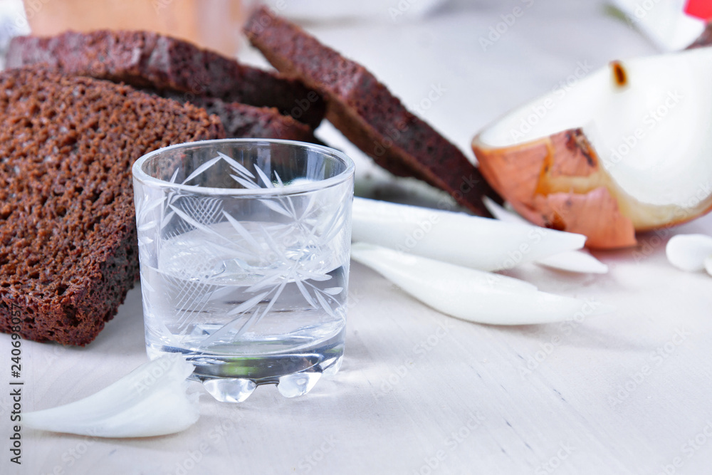 A glass of vodka and appetizer - onion and black bread A glass of vodka and appetizer - onion and black bread