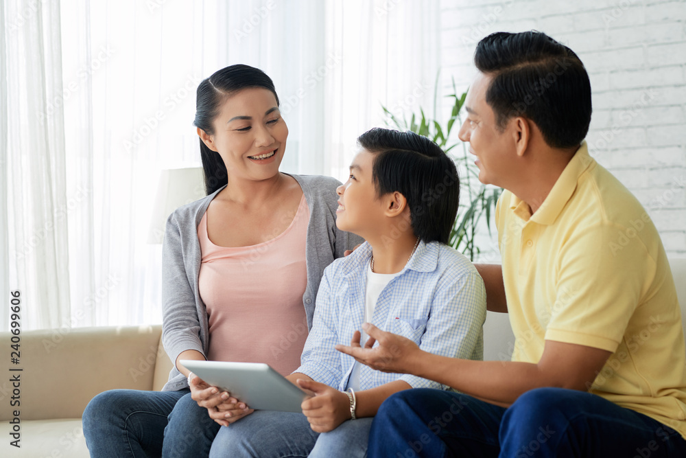 Happy Asian family with digital tablet having fun in living room Happy Asian family with digital tablet having fun in living room