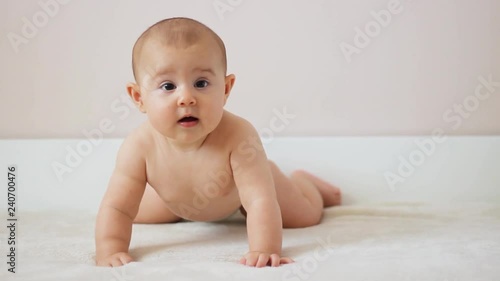 Cute little baby smiling and relaxing in bed photo