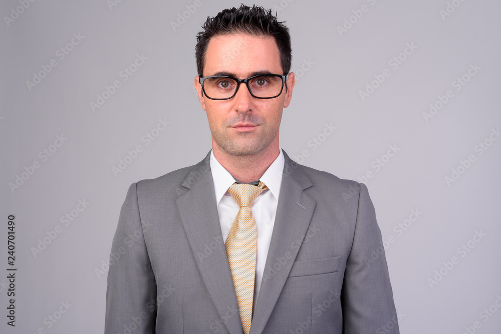 Handsome businessman in suit wearing eyeglasses against white background Handsome businessman in suit wearing eyeglasses against white background