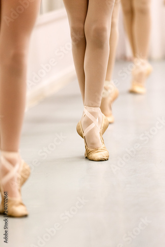 Pre-Pointe teenage girl ballet students practising barre work for ballet feet positions . Closeup in portrait format with copy space. Best images for young girl ballet poster.