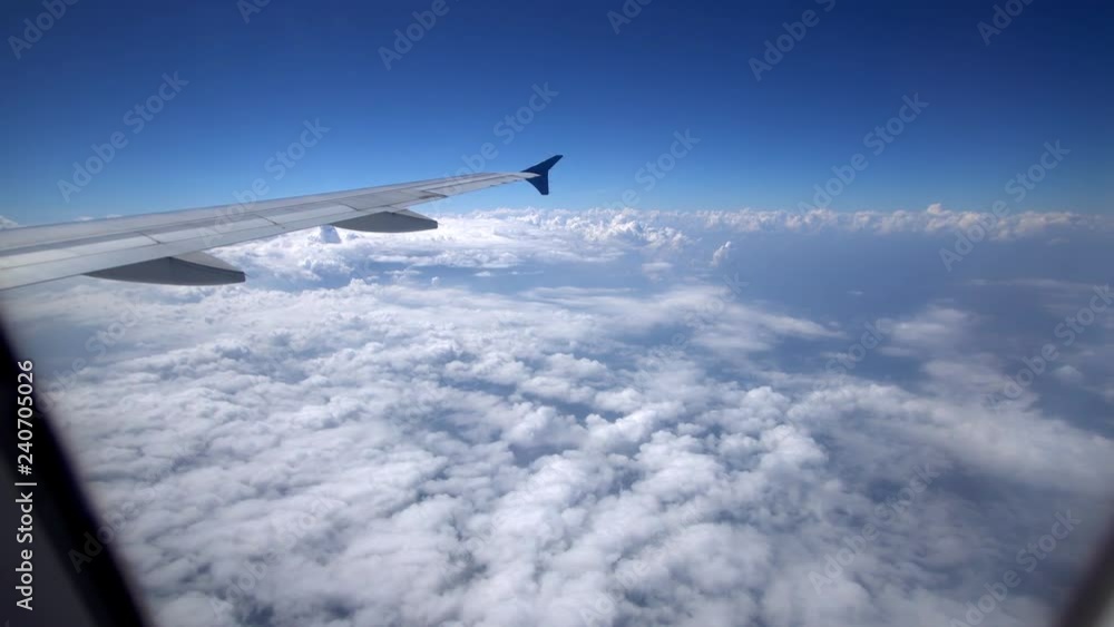 Airplane flying above cloud, View through an airplane window Airplane flying above cloud, View through an airplane window