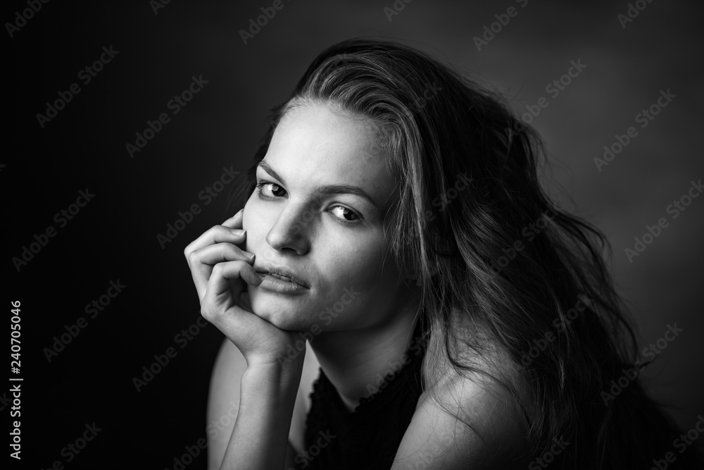 Dramatic black and white portrait of a beautiful girl on a dark background Dramatic black and white portrait of a beautiful girl on a dark background