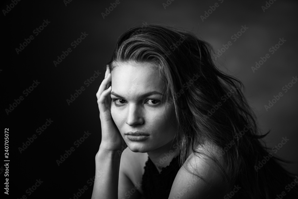 Dramatic black and white portrait of a beautiful girl on a dark background