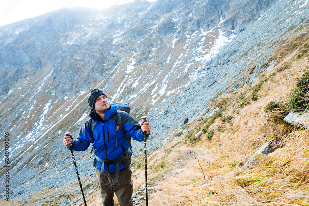 The man goes to the mountain with sticks for trekking in a wonderful autumn time The man goes to the mountain with sticks for trekking in a wonderful autumn time
