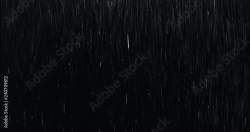 Heavy rain wall falling in front of the camera against black screen. Raindrops splashing. Rain closeup vfx insert. Practical seamlessly loopable footage. Heavy rainstorm hitting black surface. photo