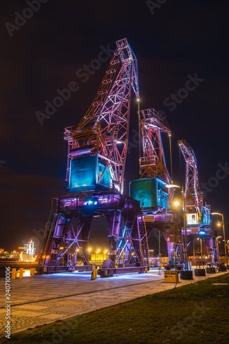 Illuminated old port cranes on a boulevard in Szczecin City at night