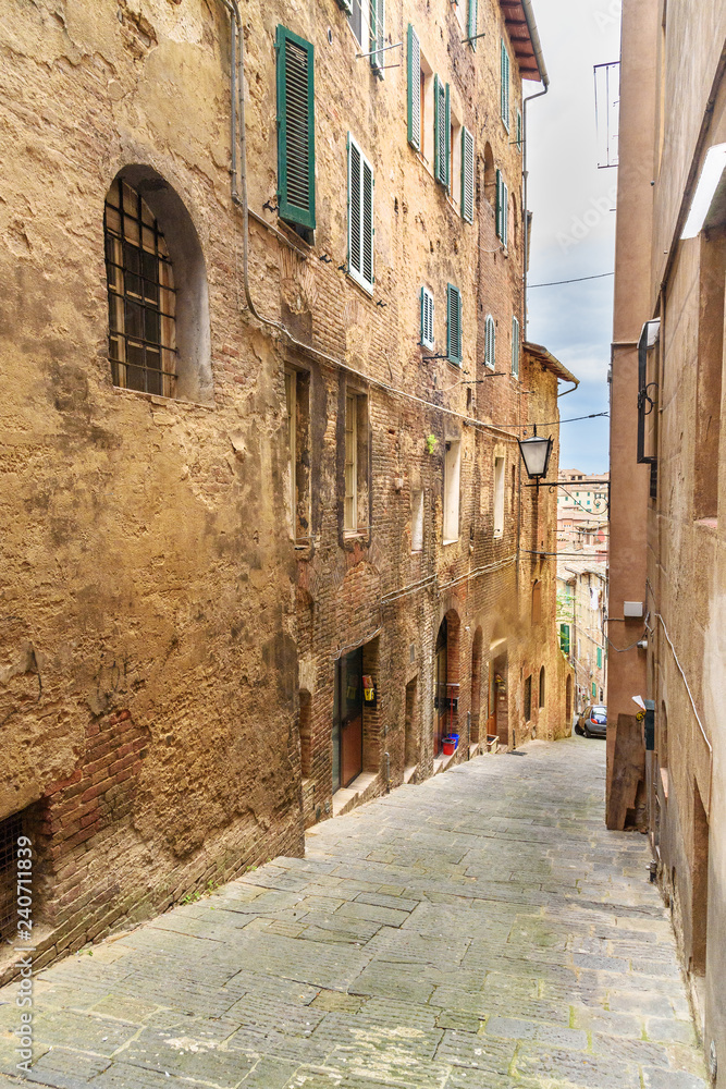 Medieval narrow street Vicolo Sambuco in Siena, Tuscany, Italy.