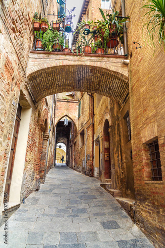 Fototapeta Naklejka Na Ścianę i Meble -  Medieval narrow street Vicolo Delle Scotte in Siena, Tuscany, Italy.