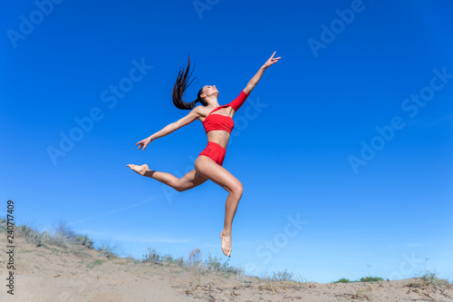 happy young woman jumping on the beach