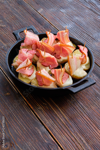 baked bacon with potatoes in a cast iron skillet