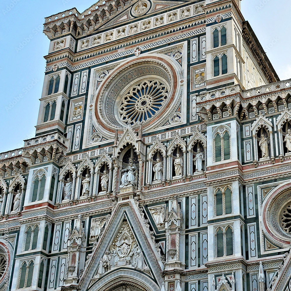Duomo Florence Cathedral (Santa Maria del Fiore). Italian Renaissance. Top of awesome marble facade with sculptures and rosette. Architectural detail. Close up. Italy, Florence