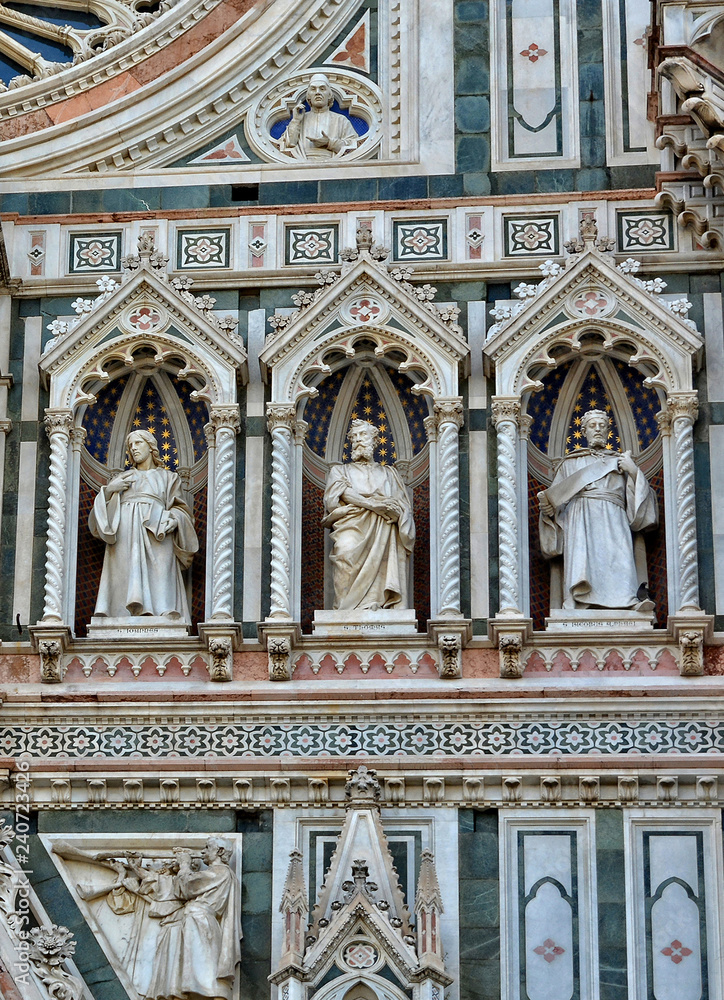 Italian Renaissance. Duomo Florence Cathedral (Santa Maria del Fiore). Architectural details of awesome marble facade with sculptures, mosaic ornament, carving. Italy, Florence