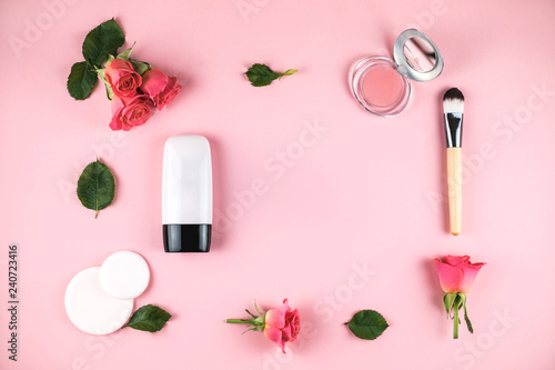 Flat lay composition with concealer, blush, flowers.