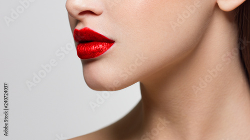 Sexual full lips. Natural gloss of lips and woman's skin. The mouth is closed. Increase in lips, cosmetology. Orange lips and long neck. Great summer mood with open eyes.