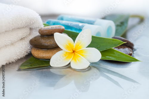   ropical flowers  bowl of water  towel and oil tube. Body care and spa concept