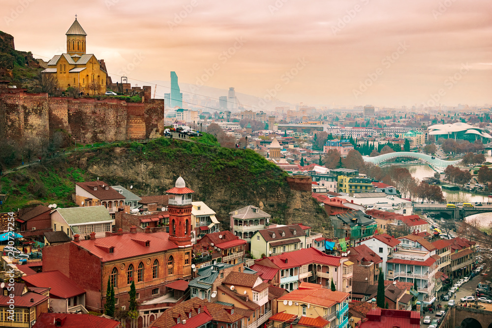 Different angle view on famous Tbilisi baths District, Abanotubani with church inside Narikala fortress and mosque in old town. City panorama in background