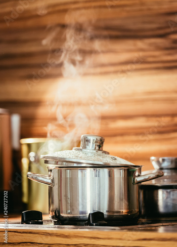 Steaming metal pot in the kitchen, wood