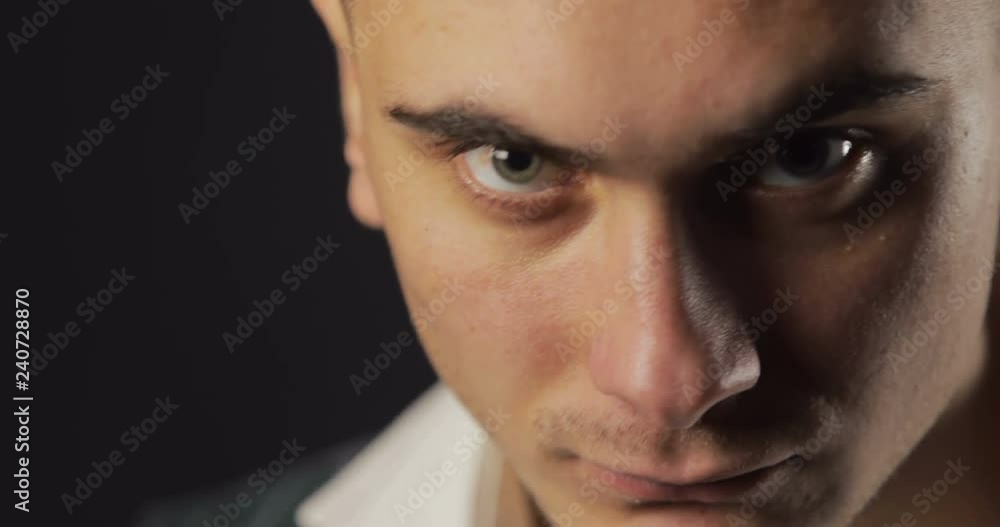 Confident, successful man is looking seriously for the camera, isolated shoot in the black background Confident, successful man is looking seriously for the camera, isolated shoot in the black background