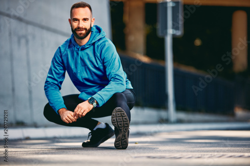 Bearded man stretching before running marathon. Healthy lifestyle concept.