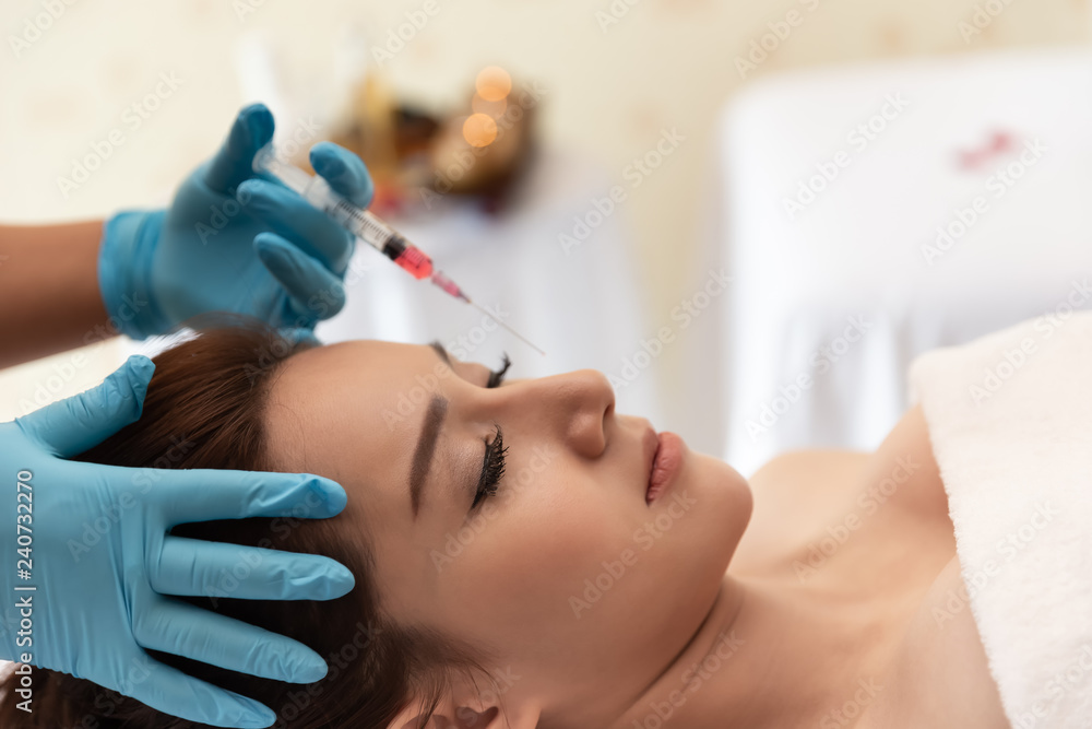 close up of Asian pretty, attractive, charming as a beautician injects hiluronic acid in the face of the girl's patient to smooth out wrinkles. Cosmetology mesotherapy for facial close up of Asian pretty, attractive, charming as a beautician injects hiluronic acid in the face of the girl's patient to smooth out wrinkles. Cosmetology mesotherapy for facial