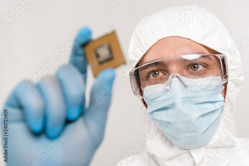 Fototapeta Naklejka Na Ścianę i Meble -  selective focus of scientist looking at microchip in latex glove isolated on grey