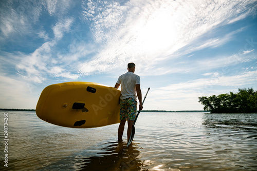 Happy man stands with a SUP board