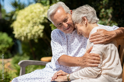 Senior couple hugging at hospital garden