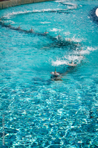 Pure turquoise water in the pool with fountains.