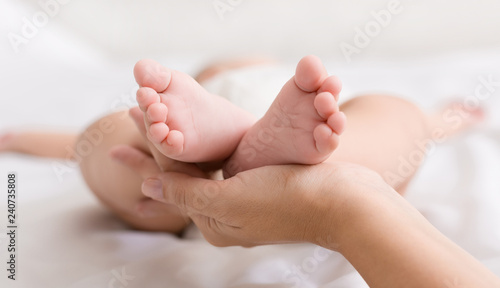 Little baby feet in mother hands closeup